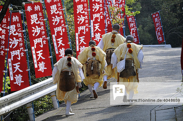 Yamabushi in traditional clothing running to the temple where the fire walking takes place  Shogoin Temple near Kyoto  Japan  Asia