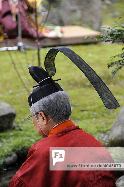 Priest with typical headdress at a Shinto ceremony  Aoi Festival  sitting at the holy stream in the Kamigamo Shrine  Kyoto  Japan  Asia