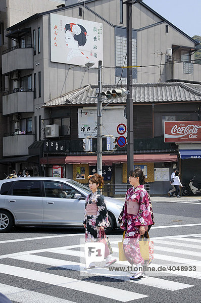 Japanerinnen mit Kimono gehen über einen Zebrastreifen im Straßenverkehr  Kyoto  Japan  Asien