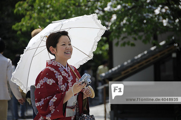 Japanerin mit Kimono Sonnenschirm und Fotoapparat in einem Tempel in Kyoto Japan Asien