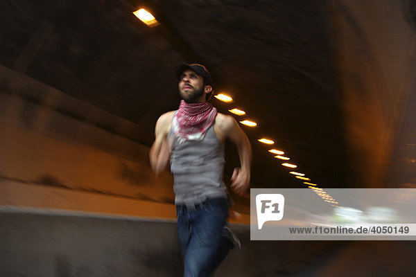 Man wearing Palastinien scarf running through a tunnel  Stuttgart  Baden-Wuerttemberg  Germany  Europe