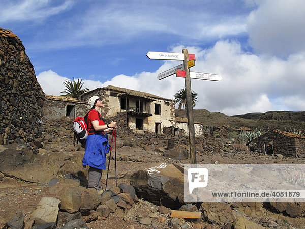 Wanderin  Wegweiser und verlassene Häuser in Contreras nahe Playa Santiago  La Gomera  Kanarische Inseln  Kanaren  Spanien  Europa