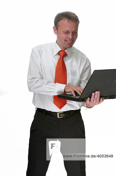 Geschäftsmann mit Hemd und roter Krawatte arbeitet am Laptop