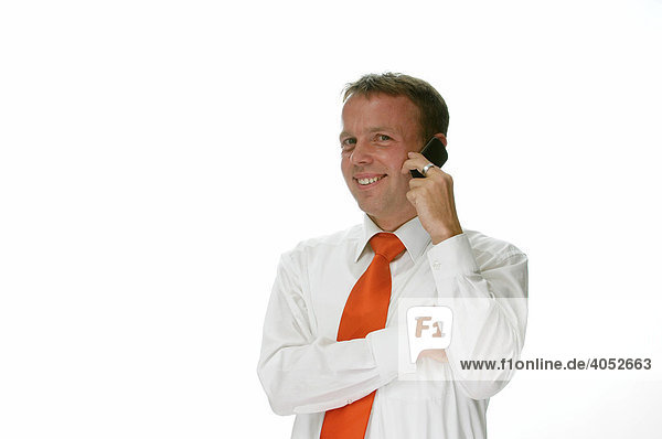 Geschäftsmann mit Hemd und roter Krawatte telefoniert mit Handy und lächelt