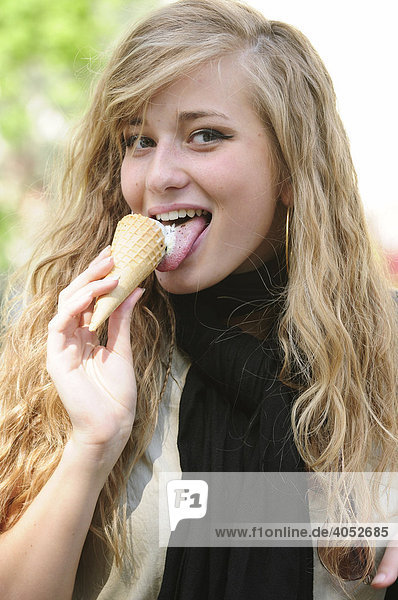 Blonde  long-haired  beautiful woman eating an ice-cream