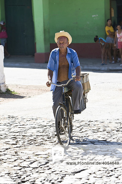 Cuban man  cycling  Trinidad  Sancti-Spíritus Province  Cuba  Latin America  America