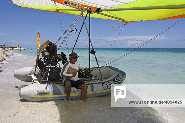 Pilot of a motorised hang glider waiting for passengers on a beach  UL-Trike  Ultra Light airplane with a life boat  Varadero  Cuba  Caribbean  Central America  America
