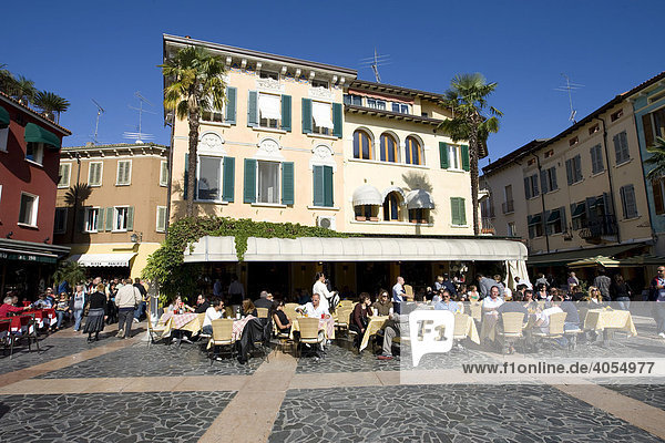 Tourists sitting in a restaurant on the promenade of Sirmione  Lake Garda  Lago di Garda  Lombardy  Italy  Europe