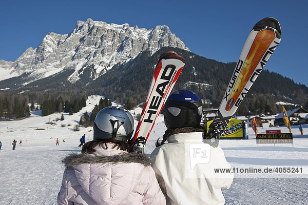 Two female skiers looking towards Zugspitze mountain  Tyrol  Austria  Europe