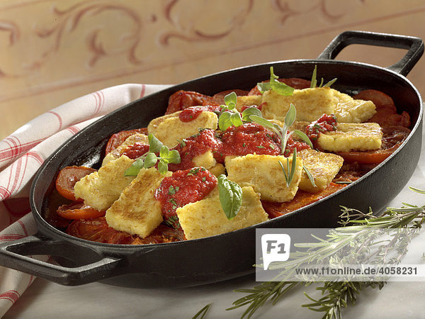 Grilled polenta with tomatoes in a pan