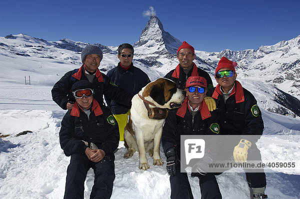 Japanese skiers and a St Bernard dog wearing a cask of rum marked with the Swiss Cross  Matterhorn Mountain  Zermatt  Valais or Wallis  Switzerland  Europe