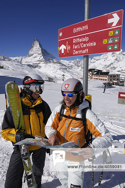 Skiers at a ski run sign  Matterhorn Mountain  Zermatt  Valais or Wallis  Switzerland  Europe