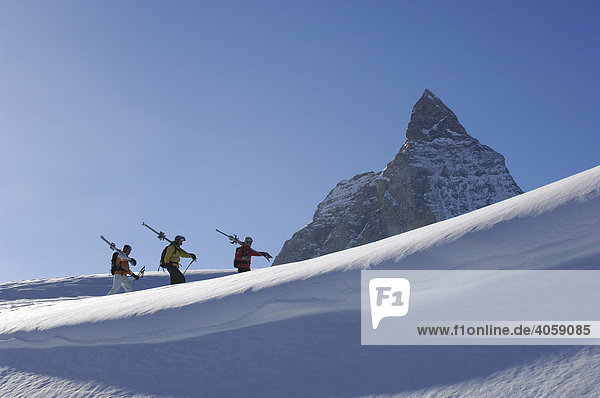 Back country skiers  freeriders  hiking over the Sandiger Boden ski area in front of the Matterhorn Mountain  Zermatt  Valais or Wallis  Switzerland  Europe