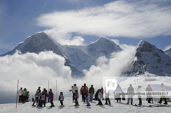 Children's ski circus on the Mt Maennlichen with view of Mt Eiger  Mt Moench and Mt Tschuggen  Grindelwald  Bernese Alps  Switzerland
