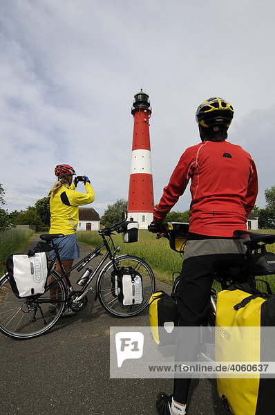 Radfahrer vor dem Leuchtturm der Insel Pellworm  Nordfriesland  Nordsee  Schleswig-Holstein  Deutschland  Europa