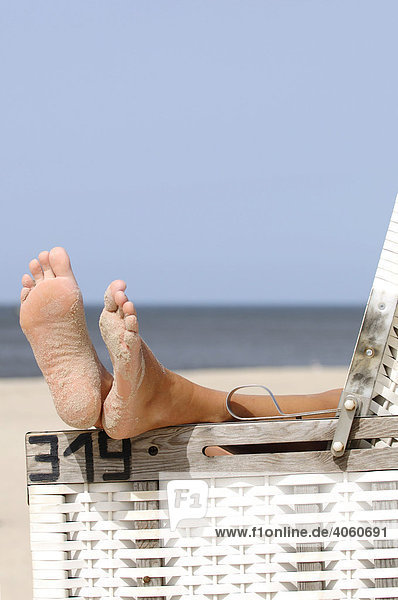 Feet resting on a roofed wicker beach chair near Wenningstedt  Sylt  North Frisian Island  North Sea  Schleswig-Holstein  Germany  Europe