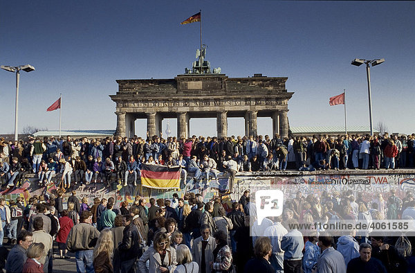 Fall der Berliner Mauer: Menschen aus Ost- und West-Berlin sind auf die Mauer am Brandenburger Tor geklettert  Berlin  Deutschland  Europa