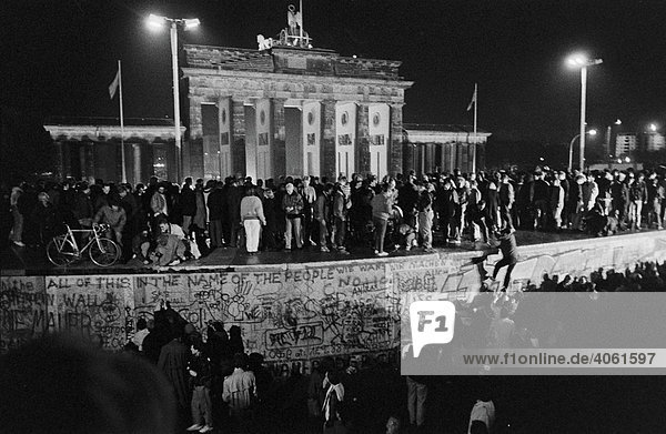 Fall of the Berlin Wall: people from East and West Berlin climbing the Wall at the Brandenburg Gate on the 9th November 1989  Berlin  Germany  Europe