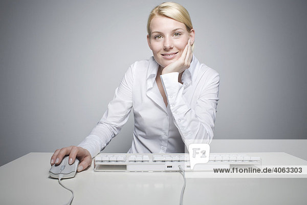 Junge blonde Frau mit Computermaus und Tastatur