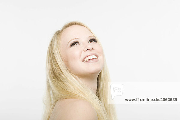 Junge blonde Frau blickt lächelnd nach oben