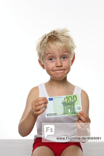 Pfiffig schauender Junge mit 100 Euro-Schein