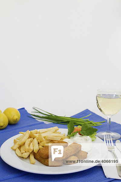 Fischstäbchen mit Pommes frites  Remouladensoße  Weißwein  Schnittlauch und Zitronen
