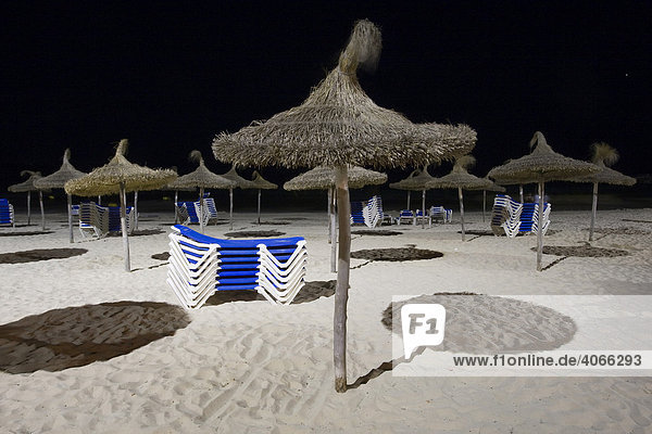 Sonnenschirme und gestapelte Liegen am Strand von Sa Coma bei Nacht  Mallorca  Balearen  Spanien  Europa