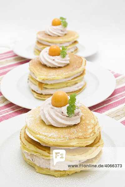 American buttermilk pancakes filled with wood berry cream  decorated with cape gooseberries and lemon balm