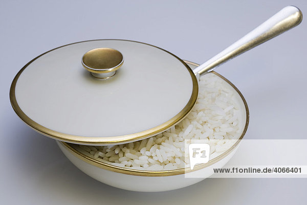Rice in a bowl with a lid and a spoon