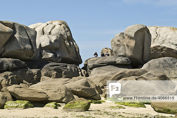 People on vacation sitting on a rock formation near to the Phare de Pontusval  Brignogan  Brittany  France  Europe