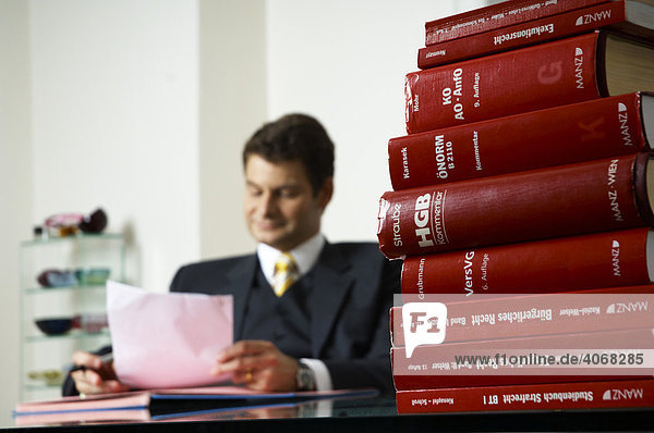Rechtsanwalt  Steuerberater  Unternehmensberater  liest einen Brief am Schreibtisch
