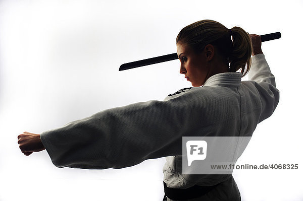 Junge Kämpferin mit Holzschwert  Gegenlichtaufnahme