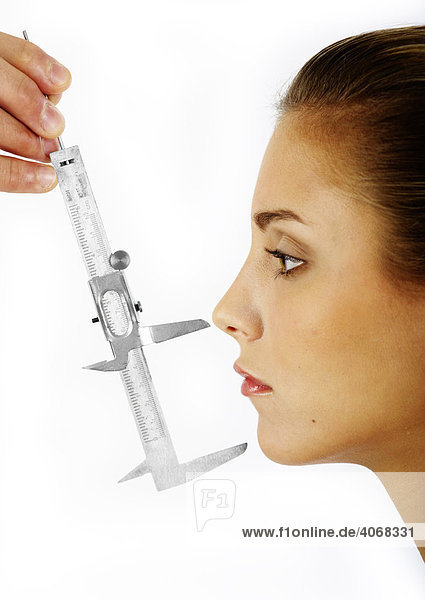 Young woman  distance between the forehead and the nose being measured with a caliper rule