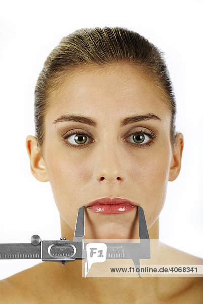 Woman's mouth being measured with a caliper rule mouth