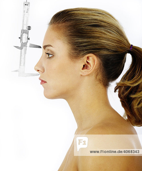 Messung des Abstandes Stirn-Nase einer jungen Frau mit einer Schublehre