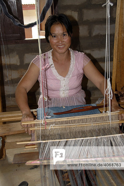 Handicraft  young woman weaving silk on a loom  Phonsavan  Xieng Khuang Province  Laos  Southeast Asia