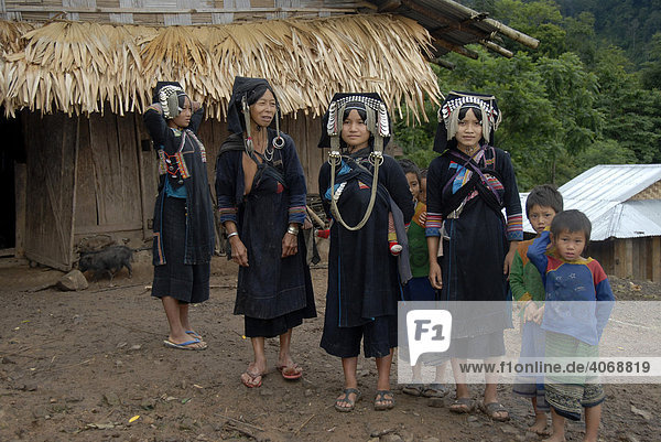 Four women of the Akha Phixo tribe in traditional costume with children  Ban Phapoun Mai  Phongsali Province  Laos  South East Asia