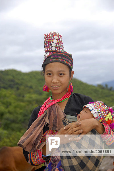 Junge Frau der Akha Pala Ethnie in traditioneller Tracht mit ihrem Baby  Ban Pakha  Phongsali Provinz  Laos  Südostasien