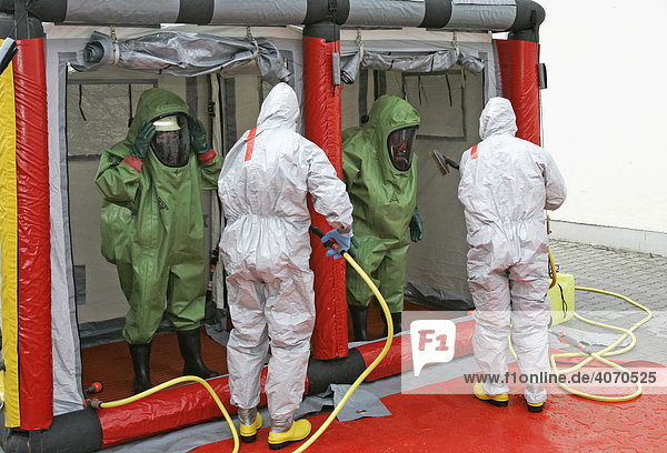 Mobiler Dekontaminationspunkt der Feuerwehr Feuerwehrleute mit Chemikalienschutzanzügen helfen bei einer Katastrophenschutzübung bei Poing Bayern Deutschland Europa