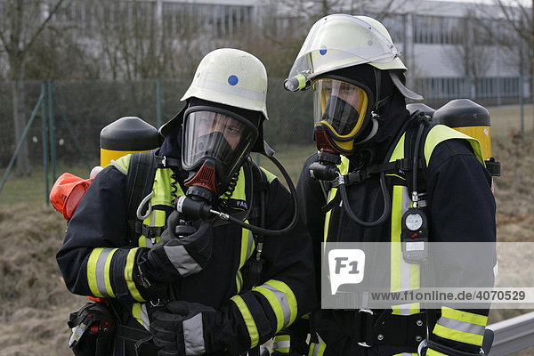 Feuerwehrleute mit Atemschutzgeräten helfen bei einer Katastrophenschutzübung bei Poing  Bayern  Deutschland  Europa