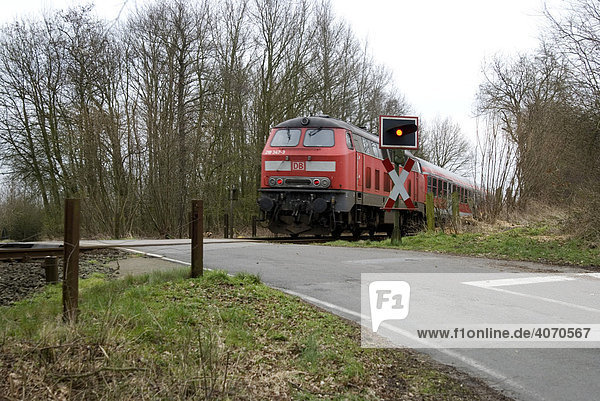 Zug durchfährt unbeschrankten Bahnübergang mit blinkender Ampelregelung  Schleswig-Holstein  Deutschland  Europa