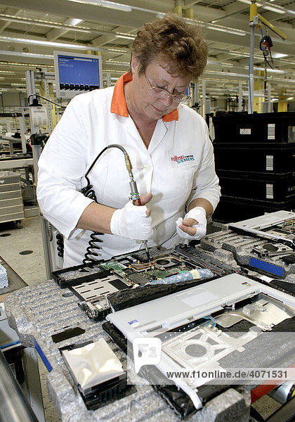 Employee of the computer production installing the mainboard into a notebook  at the Fujitsu Siemens GmbH in Augsburg  Bavaria  Germany  Europe