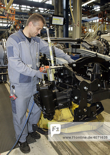 Worker during axle assembly in the underbody of a truck  manufacture  Production MAN Commercial Vehicle Corporation  Munich  Bavaria  Germany  Europe