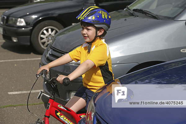 Five-year-old boy wearing a bicycle helmet riding a bike