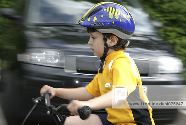 Five-year-old boy wearing a bicycle helmet riding a bike