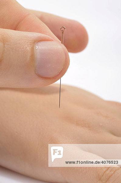 Finger stechen Akupunkturnadel in Fuß