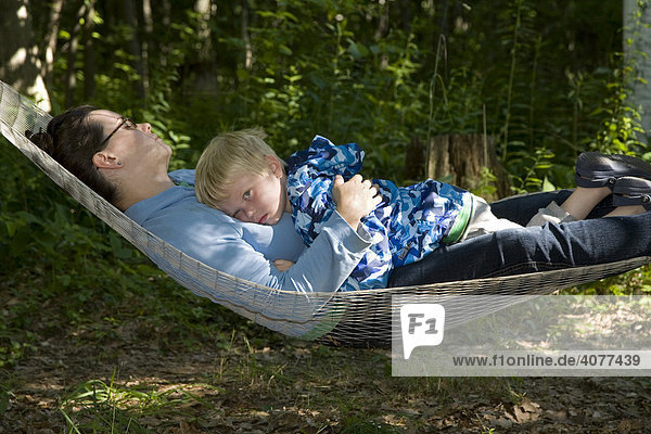 Ein 2-jähriger Junge entspannt sich mit seiner Mutter in einer Hängematte  Prairieville  Michigan  USA