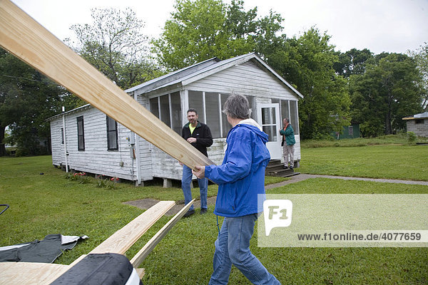 Freiwillige der United Methodist Churches Kirchen entladen Bauholz für Reparaturarbeiten am Haus einer einkommensschwachen Famile  Baldwin  Louisiana  USA Zuhause von