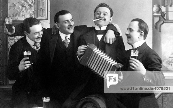 Männer trinken Bier und spielen Ziehharmonika anläßlich eines Geburtstags  historische Aufnahme  ca. 1910