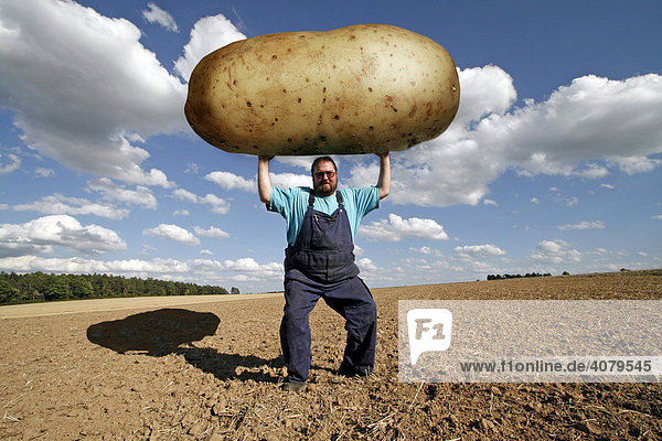 Bauer mit überdimensionaler Kartoffel  Genfood